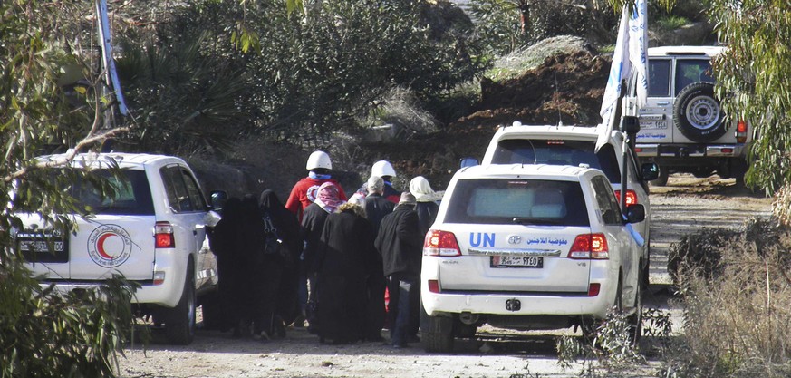 UN-Mitglieder bei der Evakuation von Frauen aus der umkämpften syrischen Stadt Homs.&nbsp;