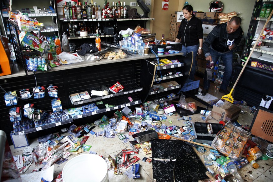 A worker of a looted mini market stands next to a reporter, in Tegucigalpa, Honduras, Friday, Dec. 1, 2017. Protests continued in Honduras Friday as incumbent President Juan Orlando Hernandez emerged  ...