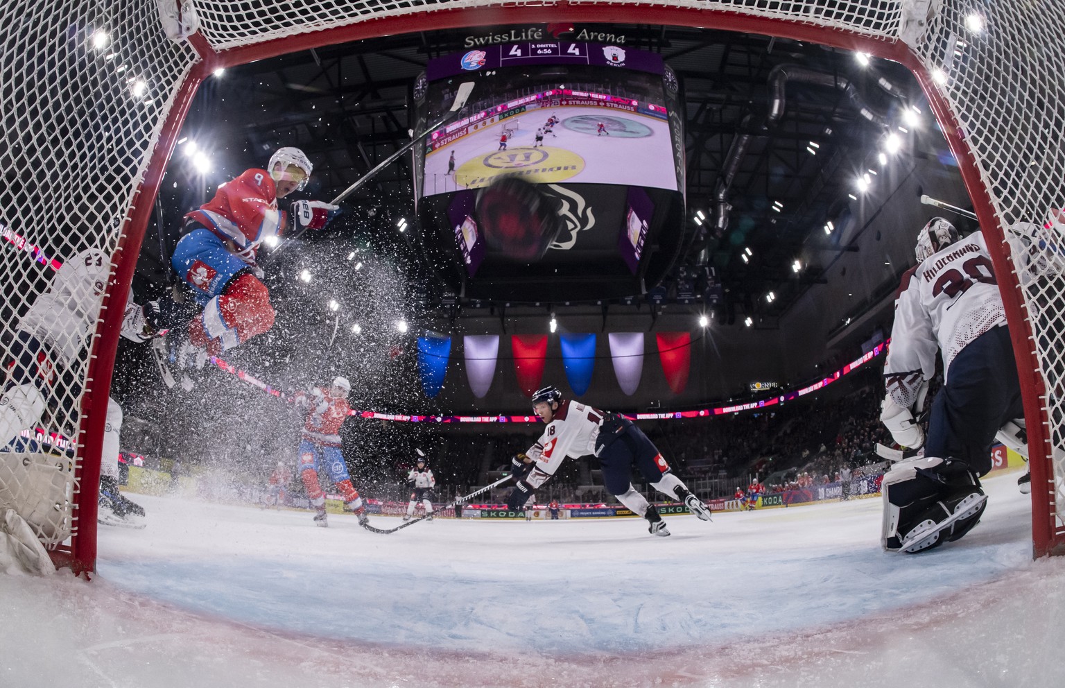 Derek Grant (ZSC), center, scores the 5:4 against Goalkeeper Jake Hildebrand (EBB), right, during the Champions Hockey League Quarter-Final match between Switzerland&#039;s ZSC Lions and Germany?s Eis ...