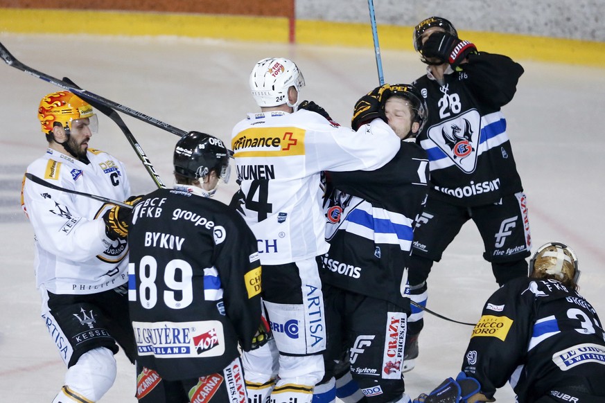 Luganos Jani Lajunen, Mitte, legt sich beim Torjubel nach seinem Tor zum 1-2 mit Fribourgs Ralph Stalder an, im vierten Eishockey Playoff-Viertelfinalspiel der National League zwischen dem HC Fribourg ...