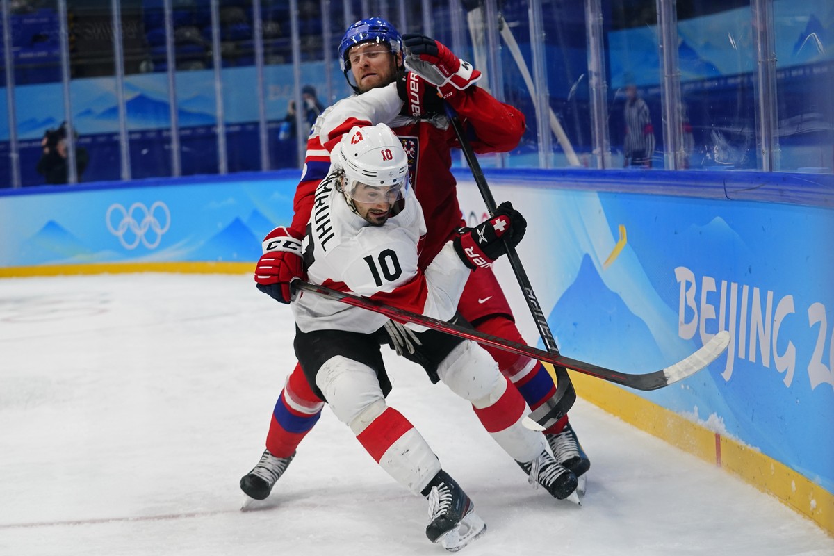 Switzerland's Andres Ambuhl (10) pushes back against Czech Republic's Jakub Jerabek during a preliminary round men's hockey game at the 2022 Winter Olympics, Friday, Feb. 11, 2022, in B ...