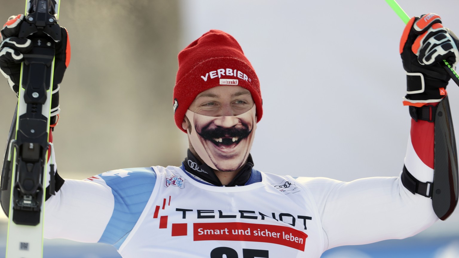 Switzerland&#039;s Justin Murisier sports a face mask as he celebrates his third place in a alpine ski, men&#039;s World Cup giant slalom in Alta Badia, Italy, Sunday, Dec.20, 2020. (AP Photo/Marco Tr ...