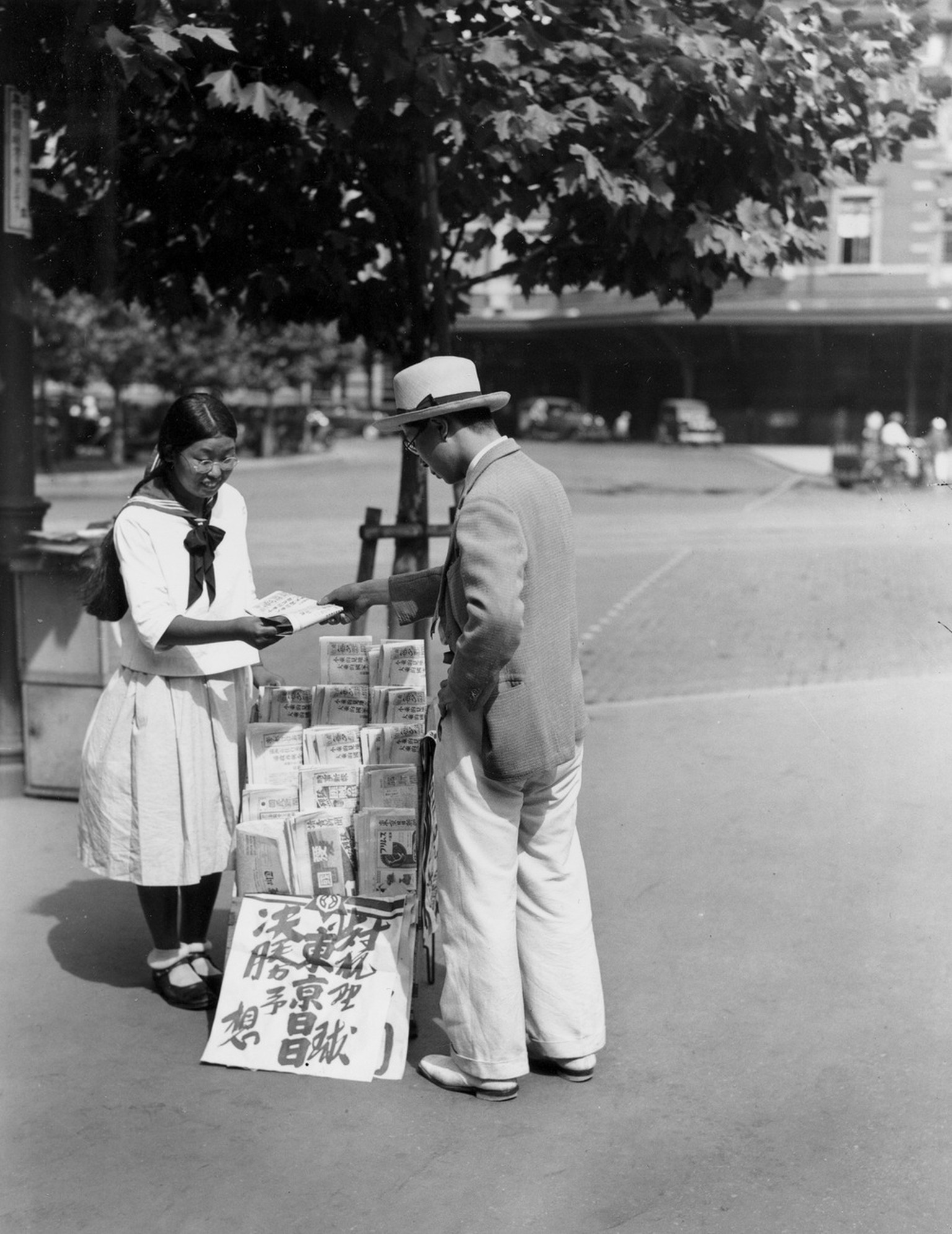 A young woman sell newspapers on a downtown street in Tokyo, Japan, on March 8, 1937. (AP Photo)