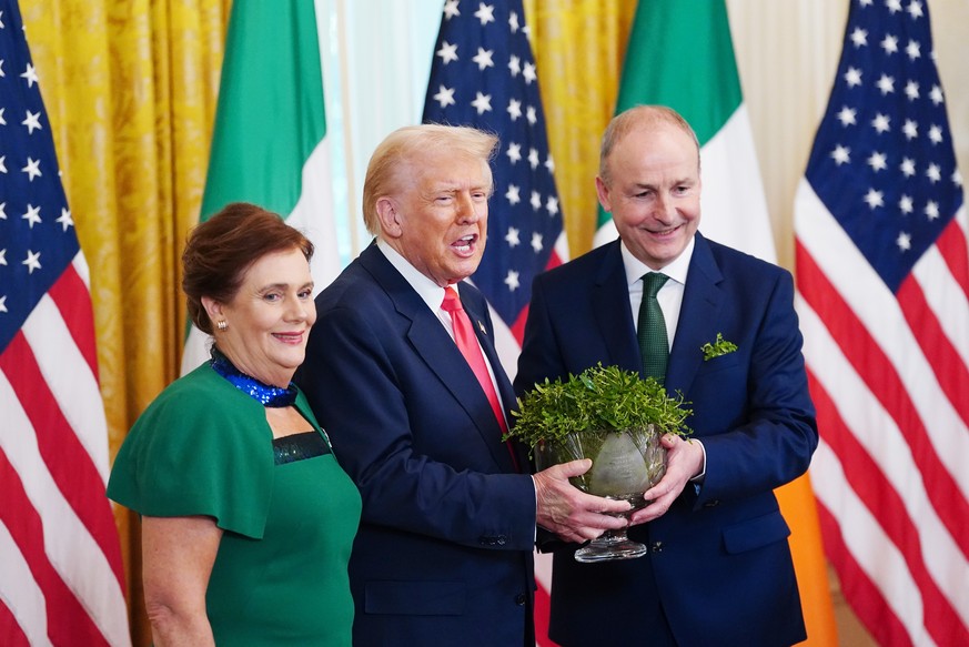 epa11959787 The Taoiseach of Ireland Micheal Martin (R) and his wife Mary O'Shea (L) present US President Donald Trump with the traditional shamrock bowl during a St Patrick's Day reception  ...