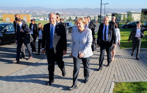 epa05427220 German Chancellor Angela Merkel (C-R) speaks to President of Switzerland Johann Schneider-Ammann (C-L) at the ASEM Village on the sidelines of the the 11th Asia-Europe Meeting (ASEM) Summi ...