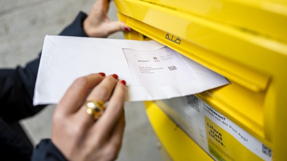 Eine Frau wirft ein Couvert mit Abstimmungsunterlagen fuer die Briefliche Stimmabgabge in einen Briefkasten der Post, am Dienstag, 17. September 2024 in Zuerich. .Die Schweizer Stimmbevoelkerung stimm ...