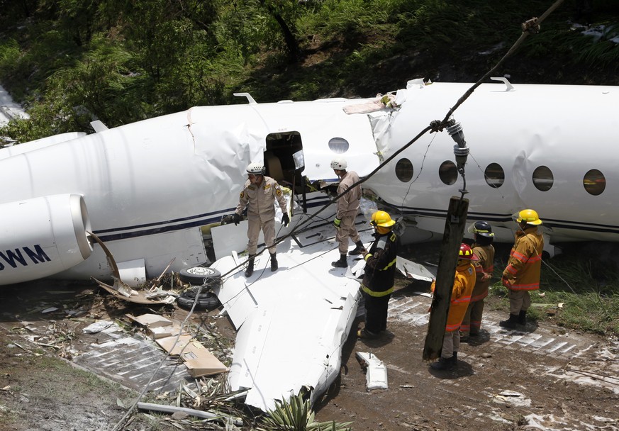 Emergency crew work at the wreckage site where a private jet crashed, in Tegucigalpa, Honduras, Tuesday, May 22, 2018. The white Gulfstream jet crashed off the end of the runway at Tegucigalpa&#039;s  ...