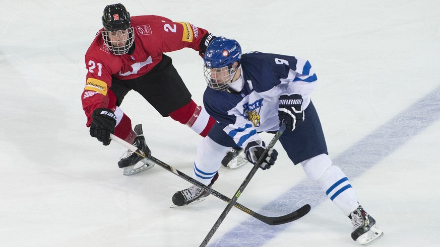 Switzerland&#039;s Robin Fuchs, left, und Finland&#039;s Vili Saarijarvi, right, fight for the puck, during a ice hockey U18 World Championships match between Switzerland and Finland, at the ice stadi ...