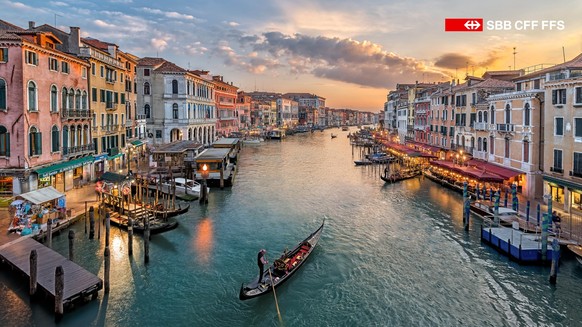 Ein friedlicher Moment auf dem Canal Grande in Venedig, wo Gondeln sanft durch das abendliche Licht der Lagunenstadt gleiten.