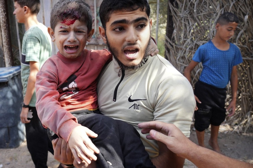 A wounded boy is carried after an Israeli strike in Deir Al-Balah, southern Gaza Strip, Thursday, Nov. 9, 2023. ( AP Photo/Hatem Moussa)