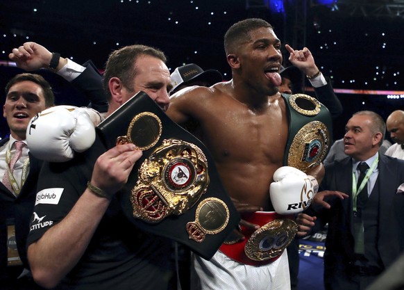 British boxer Anthony Joshua, centre, celebrates winning against Ukrainian boxer Wladimir Klitschko following their fight for Joshua&#039;s IBF and the vacant WBA Super World and IBO heavyweight title ...