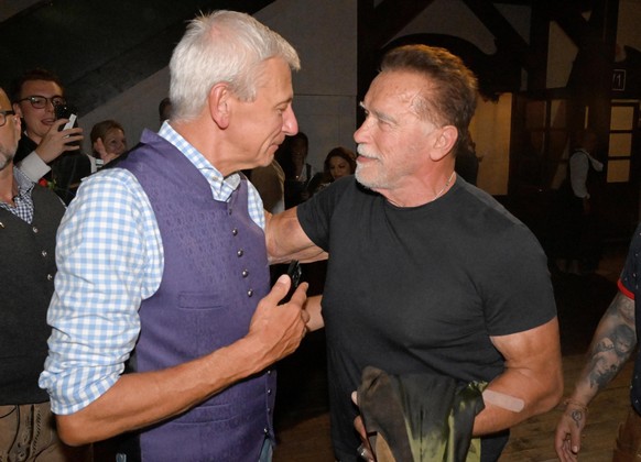 21.09.2023, Bayern, M�nchen: Der Wirt des Marstallzelts Siegfried Able (l) spricht dem Schauspieler Arnold Schwarzenegger im Marstallzelt. Die 188. Wiesn findet dieses Jahr vom 16.09.- 03.10.2023 stat ...