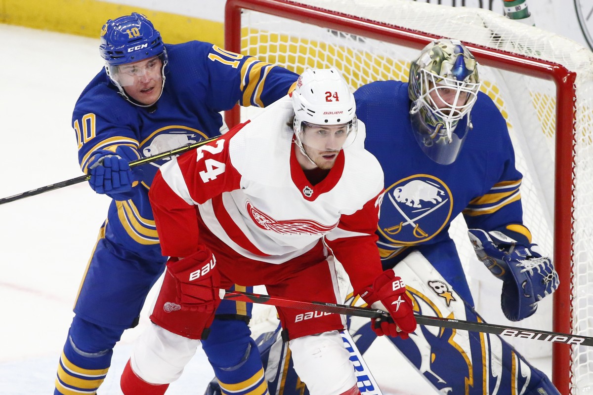 Buffalo Sabres defenseman Henri Jokiharju (10) and Detroit Red Wings center Pius Suter (24) battle for position in front of Buffalo Sabres goaltender Aaron Dell (80) during the second period of an NHL ...
