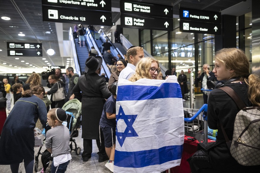 People returning from Israel on a special Swiss flight are happy to arrive, photographed on Tuesday, October 10 at Zurich airport.  Hundreds of Israelis and Palestinians are...
