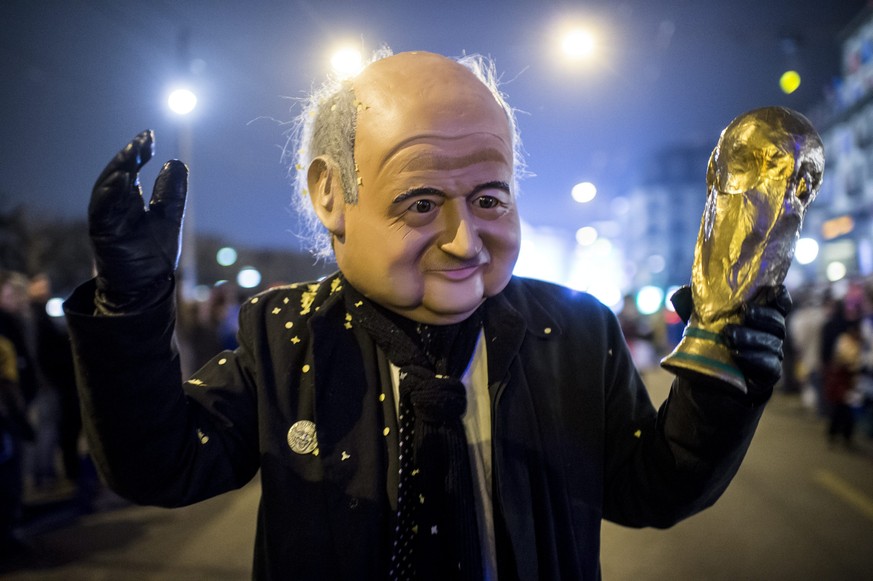 epa04624701 A reveler dressed as Sepp Blatter, FIFA President waves as Masked Guggen music bands (brass and percussion carnival bands) parade through the streets during the Monstercorso in Lucerne, Sw ...
