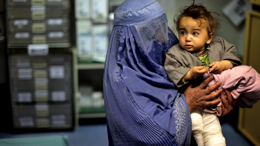 Eine Mutter in Burka haelt am Montag (17.01.11) im Rettungszentrum der Bundeswehr in Faisabad (Afghanistan) nach der Behandlung, ihren rund sieben Monate alten Sohnesauf dem Arm. Der Junge kam vor sec ...