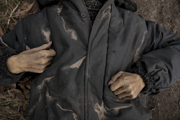 The lifeless body of a man lies on a dirt path in Bucha, Ukraine, Monday, April 4, 2022. (AP Photo/Vadim Ghirda)