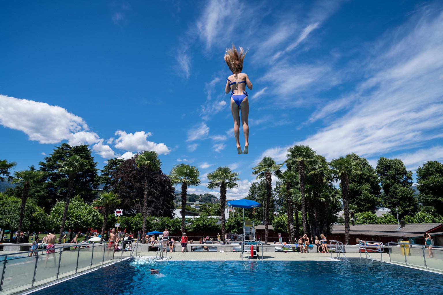 Eine Jugendliche springt vom Sprungturm nach der Wiedereroeffnung des Seebads und des Freibads Lido di Lugano, am Samstag, 20. Juni 2020. Unter den Praeventionsmassnahmen im Zusammenhang mit der Coron ...