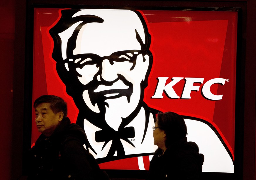 FILE - In this Monday, Feb. 25, 2013 file photo, a Chinese couple walk past a KFC restaurant at a shopping mall in Beijing. McDonald&#039;s and KFC in China faced a new food safety scare Monday after  ...