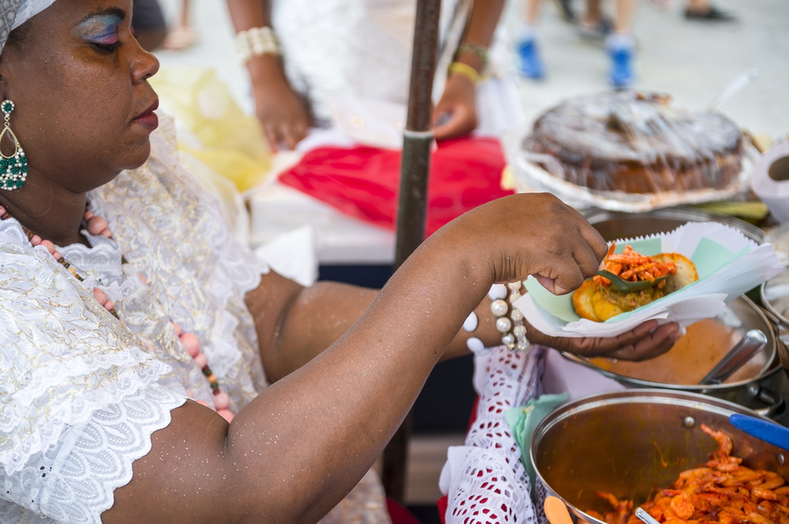 Eine Frau in den Strassen von Salvador da Bahia beim Verkauf von Acarajé.