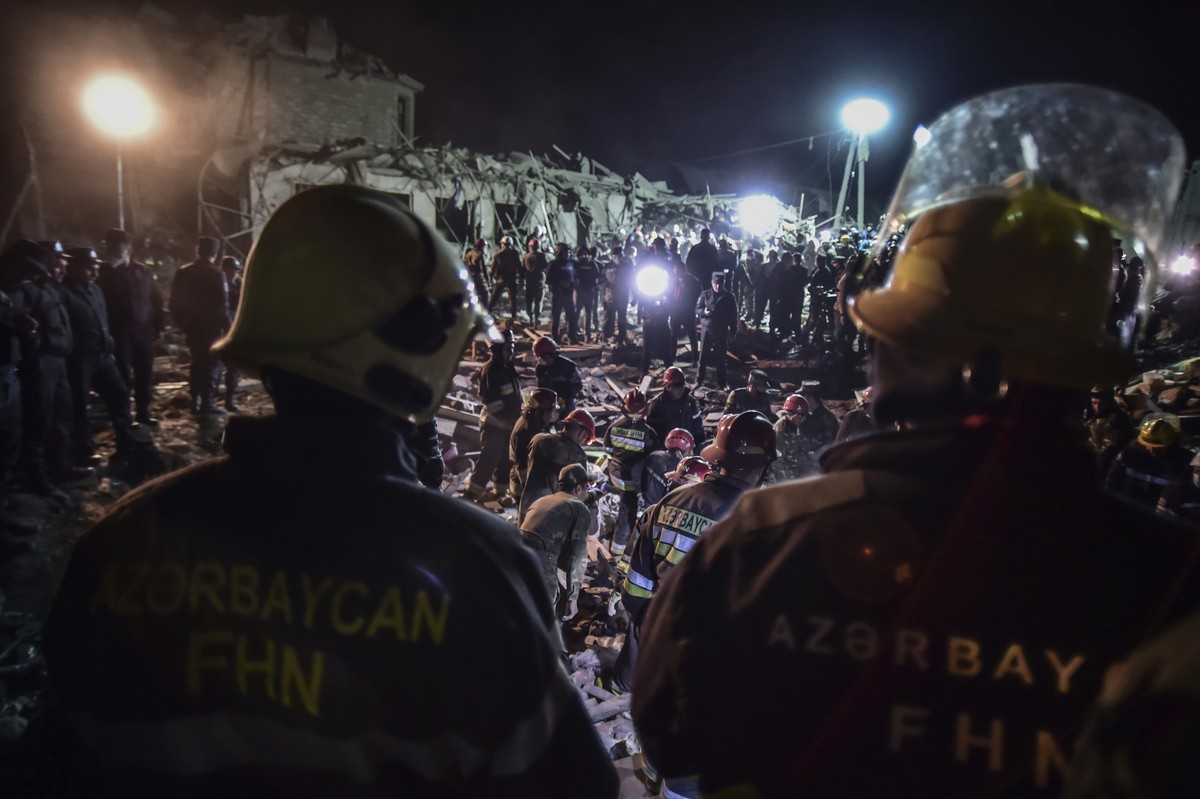 Azerbaijani soldiers and firefighters try to save survivors from destroyed houses in a residential area in Ganja, Azerbaijan's second largest city, near the border with Armenia, after rocket fire ...
