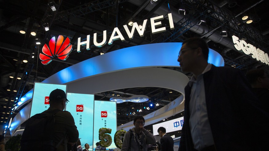 FILE - In this Oct. 31, 2019, file photo, attendees walk past a display for 5G services from Chinese technology firm Huawei at the PT Expo in Beijing. A federal appeals court refused Friday, June 18,  ...