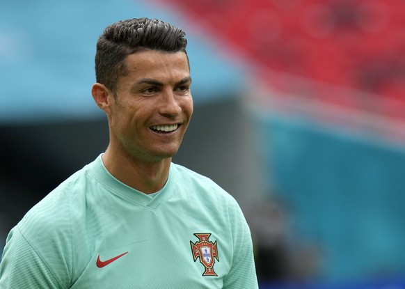 Portugal&#039;s Cristiano Ronaldo smiles during a team training session at the Ferenc Puskas stadium in Budapest, Monday, June 14, 2021 the day before the Euro 2020 soccer championship group F match b ...