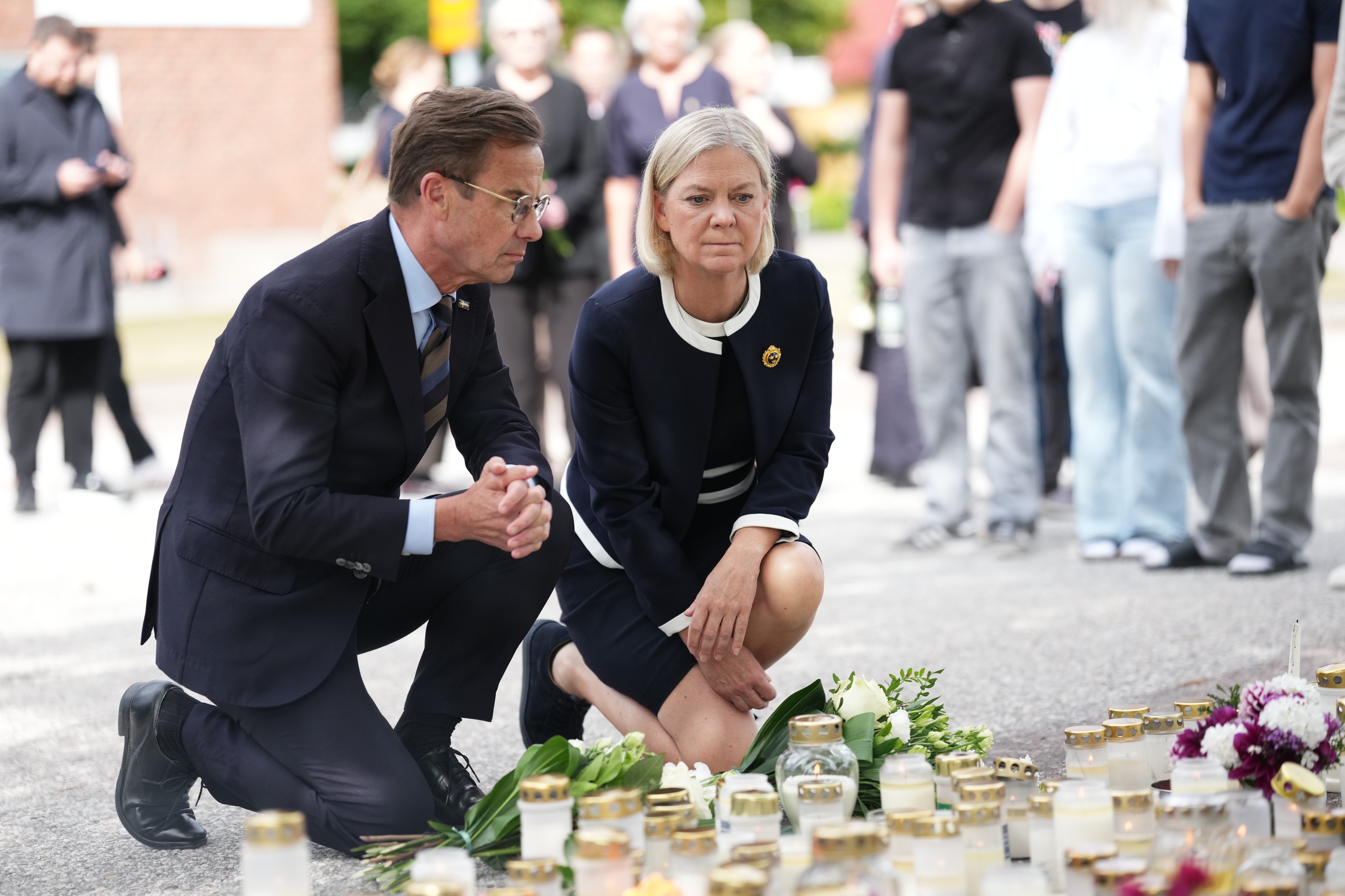 KEYPIX - Sweden's Prime Minister Ulf Kristersson, left, and Social Democratic Party leader Magdalena Andersson visit the makeshift memorial outside a school in Fagersta, Sweden, Saturday Aug. 22, ...