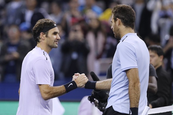 Roger Federer of Switzerland, left, shakes hands with his opponent Juan Martin del Potro of Argentina after winning their men&#039;s semifinals match of the Shanghai Masters tennis tournament at Qizho ...