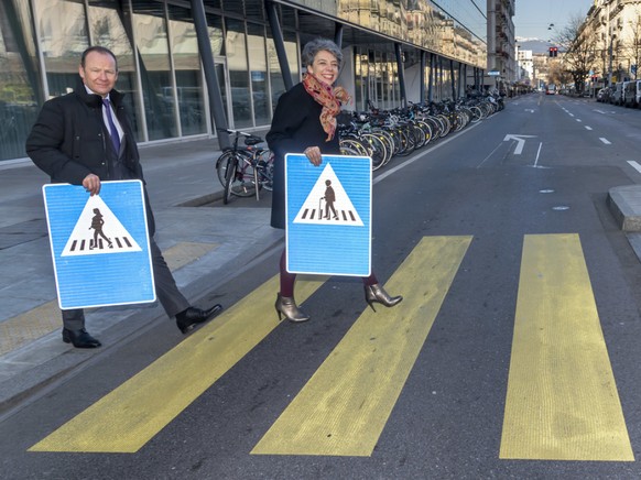 Der Genfer Staatsrat Serge Dal Busco (l.) und die Stadtpräsidentin Sandrine Salerno (r.) präsentieren auf einem Fussgängerstreifen die neuen Verkehrsschilder.