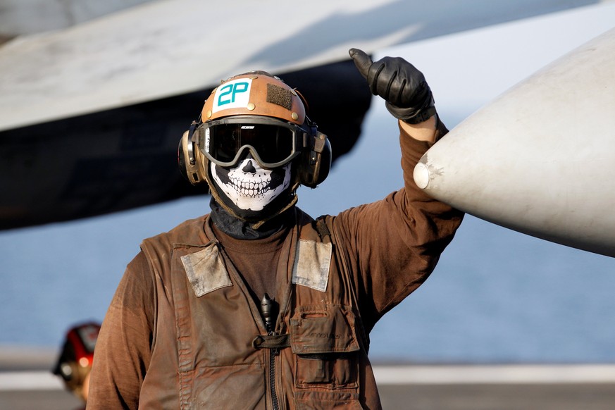 A flight deck crew member stands next to an F/A-18E Super Hornet just before take off for Mosul, Iraq to provide air-support from the USS Dwight D. Eisenhower CVN 69 carrier in Arabia Gulf, October 18 ...