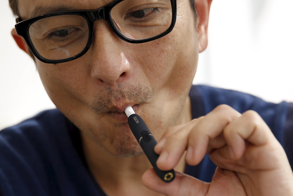 A customer tries a Philip Morris' "iQOS" smokeless tobacco e-cigarette at an iQOS store in Tokyo, Japan, March 3, 2016. REUTERS/Toru Hanai