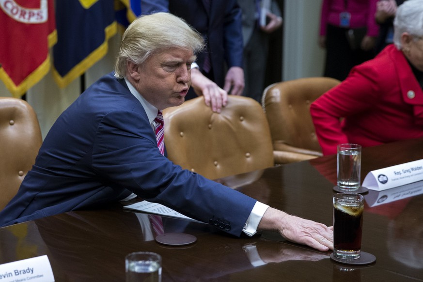 epa05841072 US President Donald J. Trump moves a drink across the table prior to participating in a health care discussion with House Energy and Commerce Chairman Greg Walden (R) and House Ways and Me ...