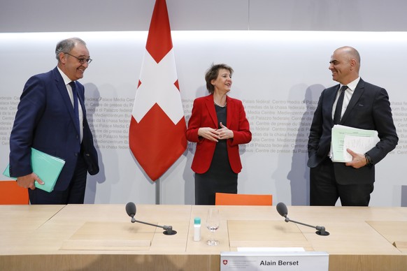 Bundespraesidentin Simonetta Sommaruga, Mitte, diskutiert mit Bundesrat Alain Berset, rechts, und Bundesrat Guy Parmelin, links, am Ende einer Medienkonferenz des Bundesrates ueber die Situation des C ...