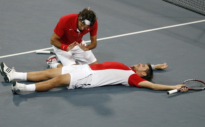 Roger Federer, left, and Stanislas Wawrinka of Switzerland react after winning their match against Bob Bryan and Mike Bryan during the semi final of the men's double tennis at the Beijing 2008 Olympic ...