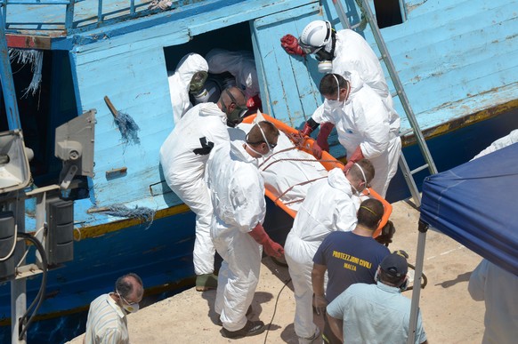 Rettungskräfte tragen ein Opfer von Bord.