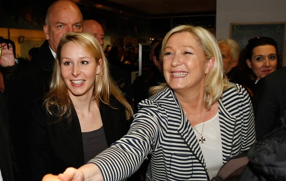 French far-right Front National leader Marine Le Pen, right, and her niece Front National Deputy Marion Marechal Le Pen, center, greet residents during an electoral visit at a market in Avignon, south ...