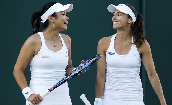 Martina Hingis of Switzerland, right, and Yung-Jan Chan of Chinese Taipei during their ladies doubles match against Xenia Knoll of Switzerland and Alize Cornet of France, during the Wimbledon Champion ...