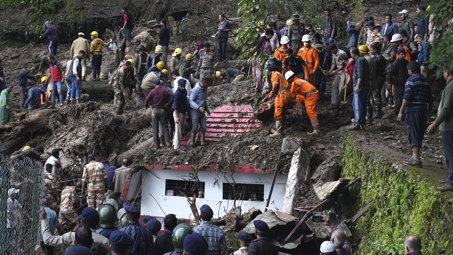 Rescuers remove mud and debris as they search for people feared trapped after a landslide near a temple on the outskirts of Shimla, Himachal Pradesh state, Monday, Aug.14, 2023. Heavy monsoon rains tr ...