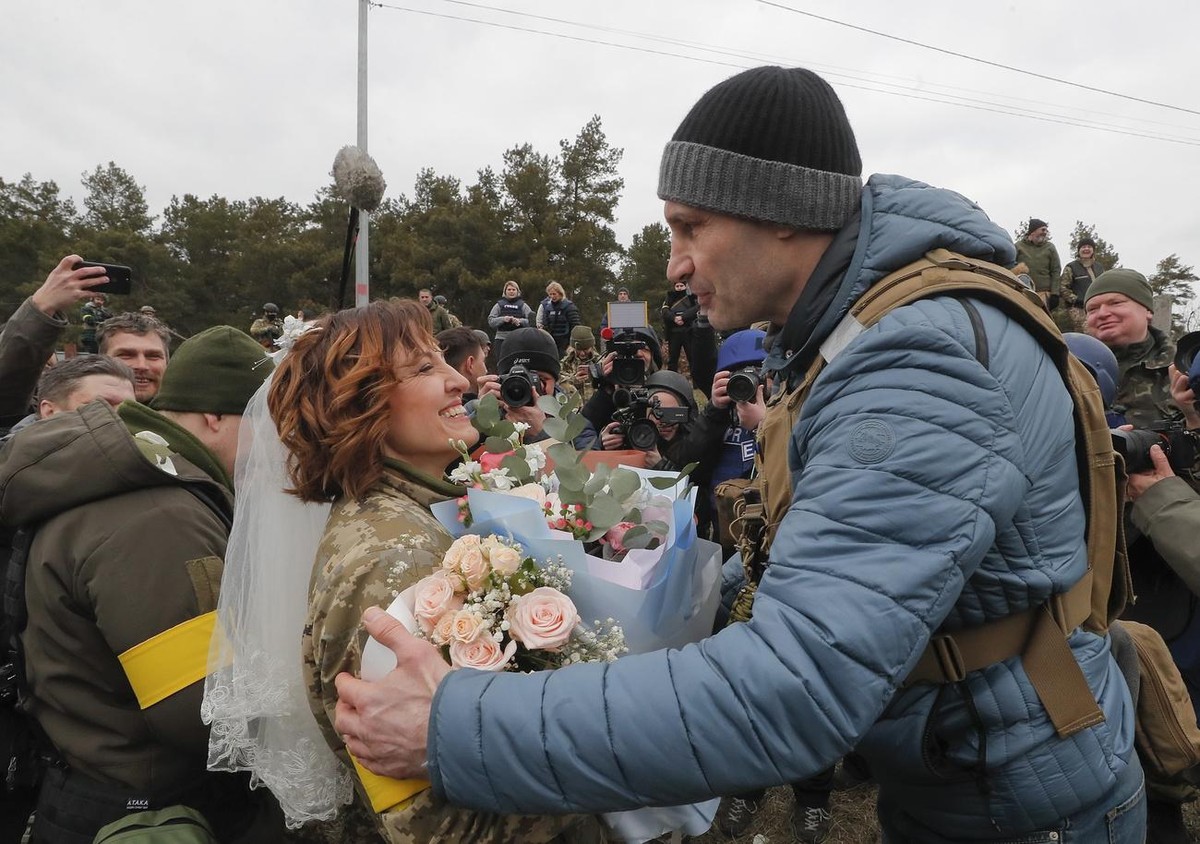 epa09805655 Kiev's Mayor Vitaly Klitschko (R) greets Ukrainian territorial defense fighter Lesya following her wedding with Valeriy (not pictured) at a blockpost near Kyiv (Kiev), Ukraine, 06 Mar ...