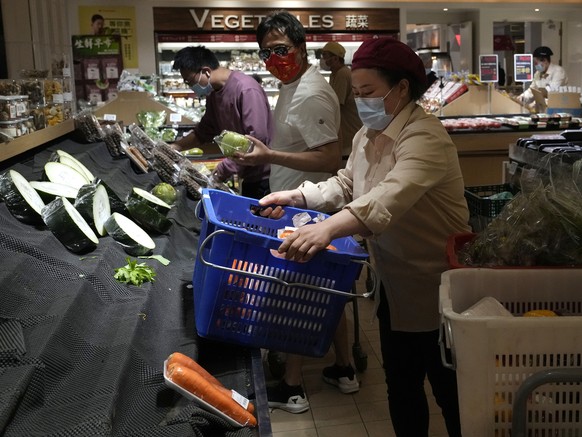 Residents wearing masks shop at a supermarket in the Chaoyang district of Beijing, Monday, April 25, 2022. Mass testing started Monday in Chaoyang district, home to more than 3 million people in the C ...