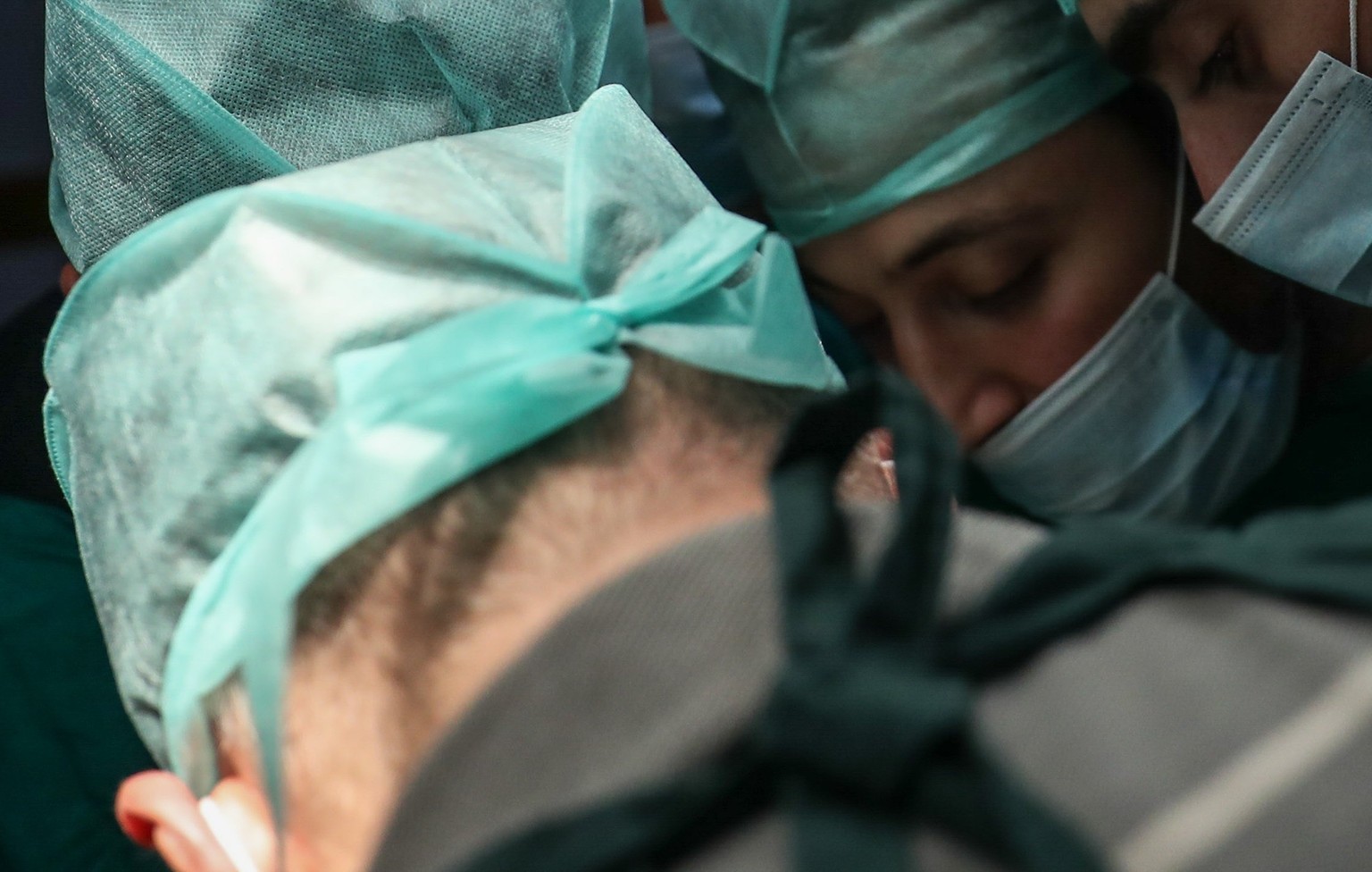 epa06260122 Dr. Husam (L) performs surgery with a consultation from another doctor via a messaging app, with his team at a unit of the Damascus Countryside Specialized Hospital in Douma, Syria, 11 Oct ...