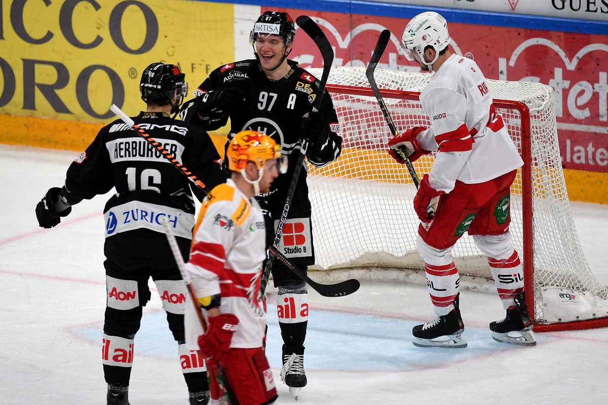 Lugano's player Calvin Thuerkauf, center, celebrates the 3-1 goal with Lugano's player Raphael Herburger, left, during the preliminary round game of National League Swiss Championship 2022/2 ...