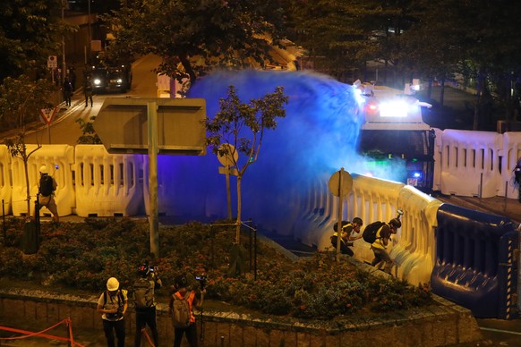 Police fire blue-colored liquid on protestors in Hong Kong, Saturday, Sept. 28, 2019. Protesters streamed onto a main road nearby and some targeted government buildings that were barricaded. Police in ...