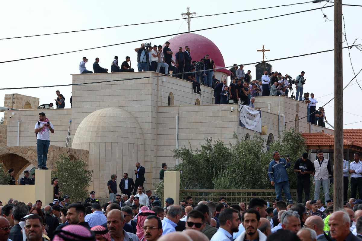KEYPIX - Mourners and journalists gather on the rooftop of a Greek Orthodox church during the funeral of victims killed in an attack on the church in Karak, Jordan, Sunday, Oct. 25, 2026. (AP Photo/Ra ...