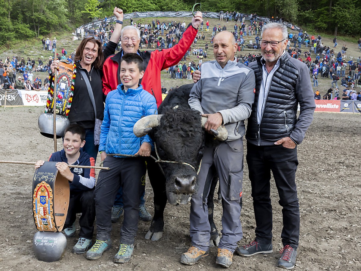 La reine des reines, Shita, pose avec ses propriétaires, la famille Terettaz après avoir remporté la finale nationale de la race d'Hérens à Aproz (VS).