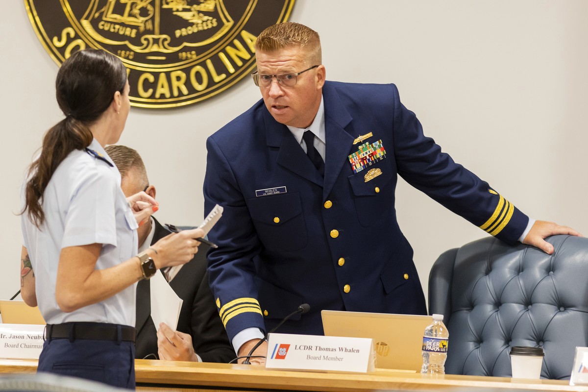 Coast Guard's Thomas Whalen speaks with another Coast Guard member during a break for the Titan marine board formal hearing inside the Charleston County Council Chambers, Monday, Sept. 16, 2024,  ...