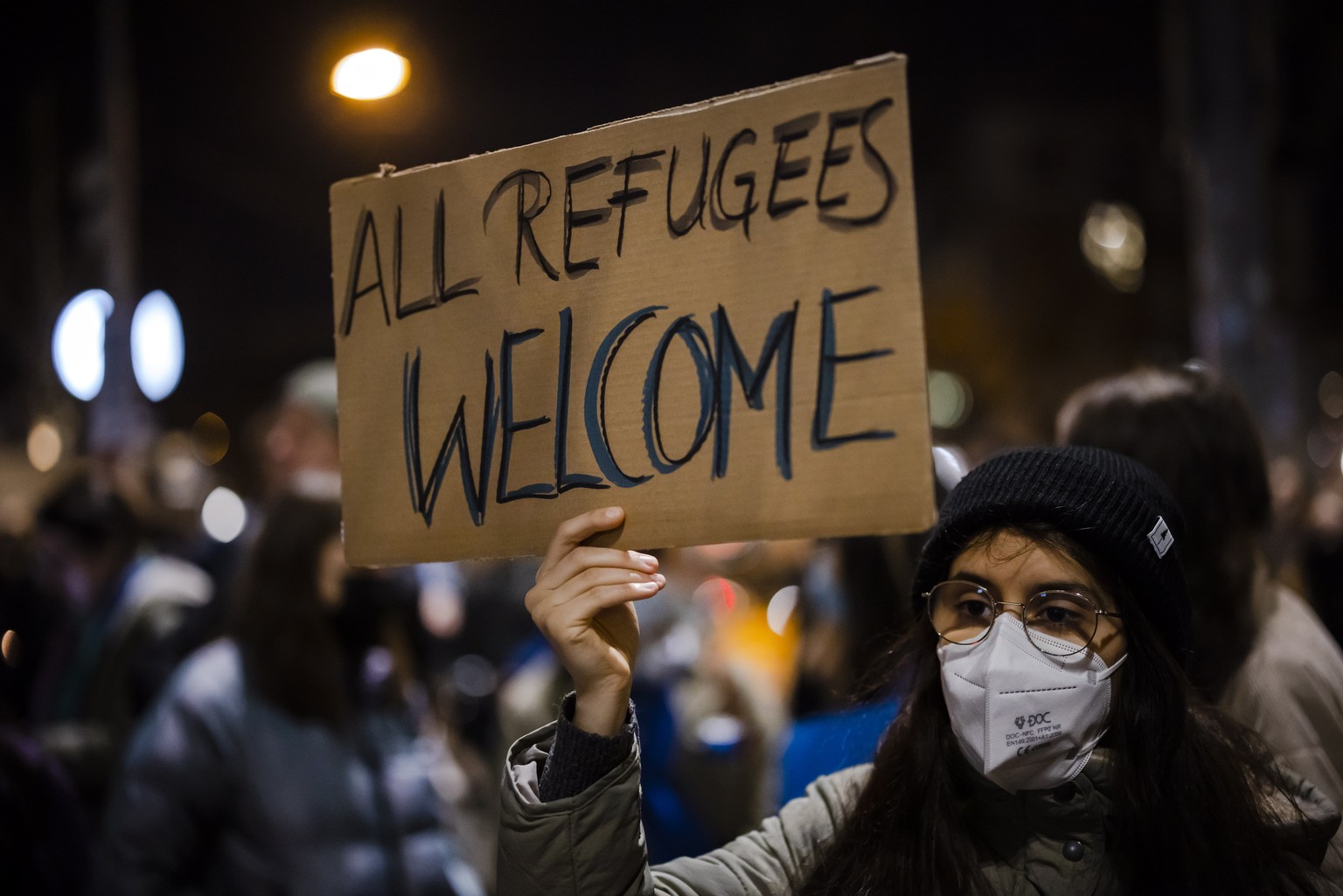 epa09799626 A protestor holds a placard reading &#039;All refugees welcome&#039; during a demonstration against the Russian invasion of Ukraine in Bern, Switzerland, 03 March 2022. Russian troops ente ...