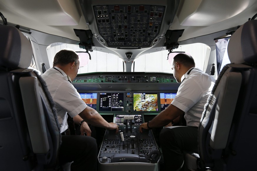 epa05410757 Two men sit in the cockpit of a new Bombardier C-Series CS100 airplane of the airline SWISS as it is presented on the occasion of the aircraft&#039;s baptism at the Zurich Airport in Klote ...
