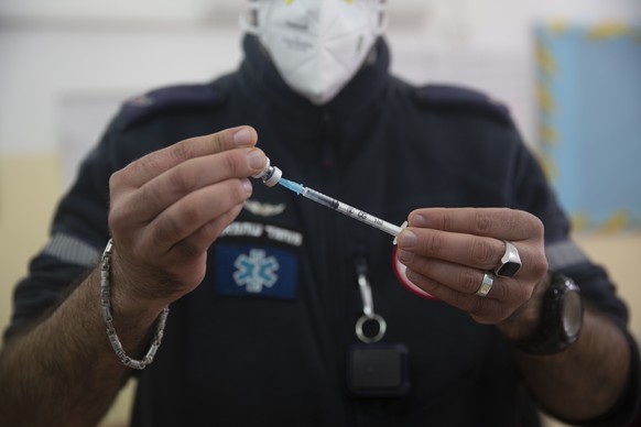 A medic with the Magen David Adom emergency service prepares a dose of the Pfizer-BioNTech COVID-19 vaccine during a one-day clinic at a school near the Al Aqsa Mosque compound to vaccinate worshipper ...